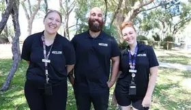a group of people standing in front of trees