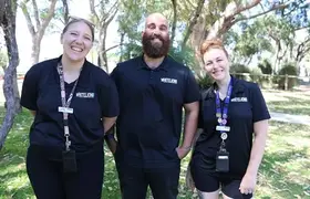 a group of people standing in front of trees