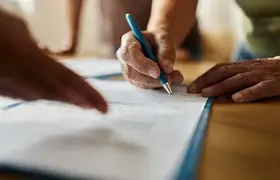 Hand signing some paperwork with a pen