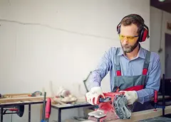 A man sanding a wooden beam