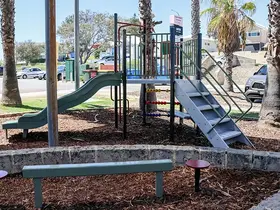 a playground with a slide and bench