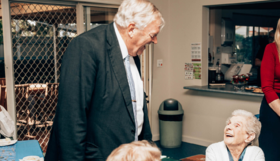 An older man talking with a woman