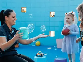 A crèche staff member and children