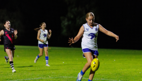 A girl kicks a football