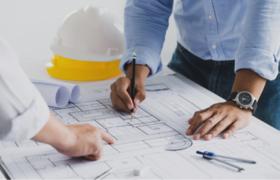 Two people looking over floor plans and planning sheets