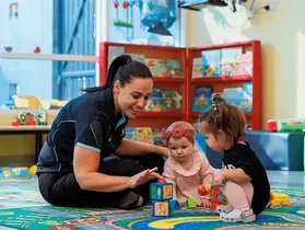 A crèche staff member and children