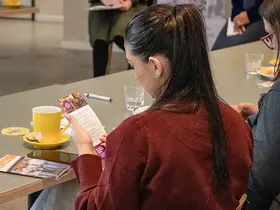 A person sitting with a coffee