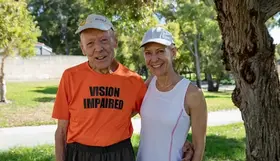 a man and woman standing together in a park