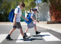a boy and girl crossing a street