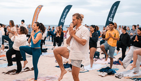 People doing yoga on the beach