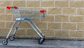 a shopping cart in front of a brick wall
