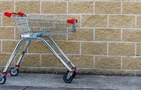 a shopping cart in front of a brick wall