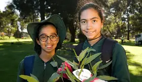 a pair of girls holding a plant