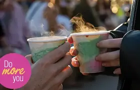 Two people holding steaming cups