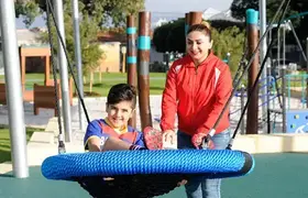 a boy and woman on a swing