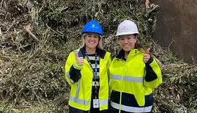 two women wearing hard hats and jackets