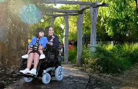 A woman in a wheelchair holds her child