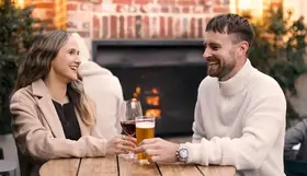 A couple enjoying a drink near the fireplace at St Brigid's Bar