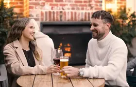 A couple enjoying a drink near the fireplace at St Brigid's Bar