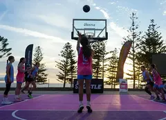 A basketball player takes a shot a the hoop
