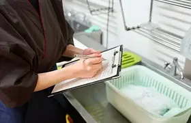 Woman white clipboard with sink in the background