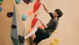 A person scaling a climbing wall