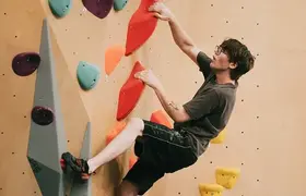 A person scaling a climbing wall