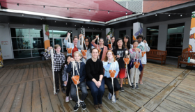 A group of people holding hanging macrame pots