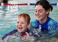 A swimming instructor and child