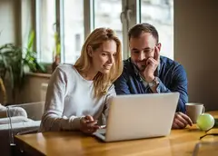 Two people using a laptop