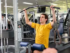 A gym user doing lat pulldowns