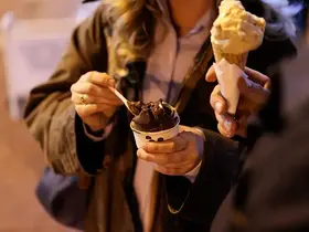 A person scooping chocolate ice cream