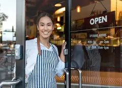 a woman wearing an apron and smiling at the camera
