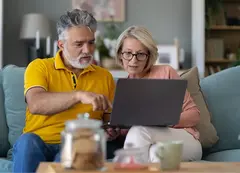 An older couple looking at a laptop