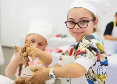 Children in chef hats rolling dough