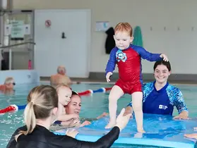 A child balances on a floating pad