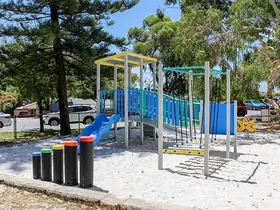 a playground with a slide and colorful poles