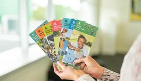 a hand holding a group of brochures