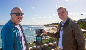 Coastal Ward Councillors Tony Krsticevic and Rob Paparde standing at a coastal lookout beside a CoastSnap monitoring station, with Mettams Pool in the background.