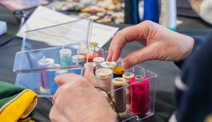 Hands hovering over a set of fabric threads