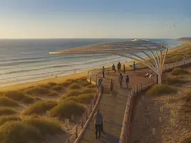 a group of people walking on a boardwalk near a beach