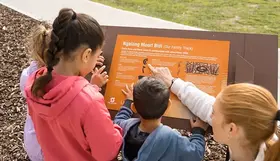 Children reading a plaque