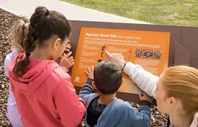 Children reading a plaque