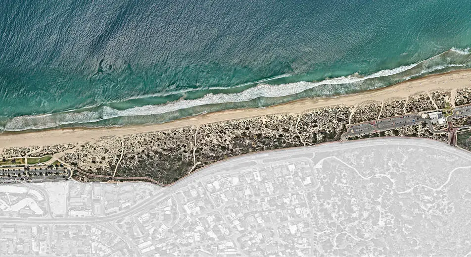 a beach with a city and water
