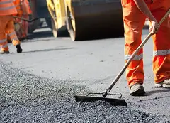 Workers smoothing fresh asphalt