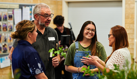 People talking and holding plants